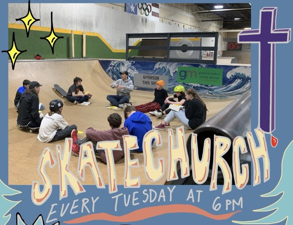 Riders sitting on the ramps under a painted Skate Church wall